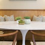 Interior Design Redondo Beach white marble tulip table dining room with wooden banquette and wishbone chairs. Manhattan Beach modern coastal home.