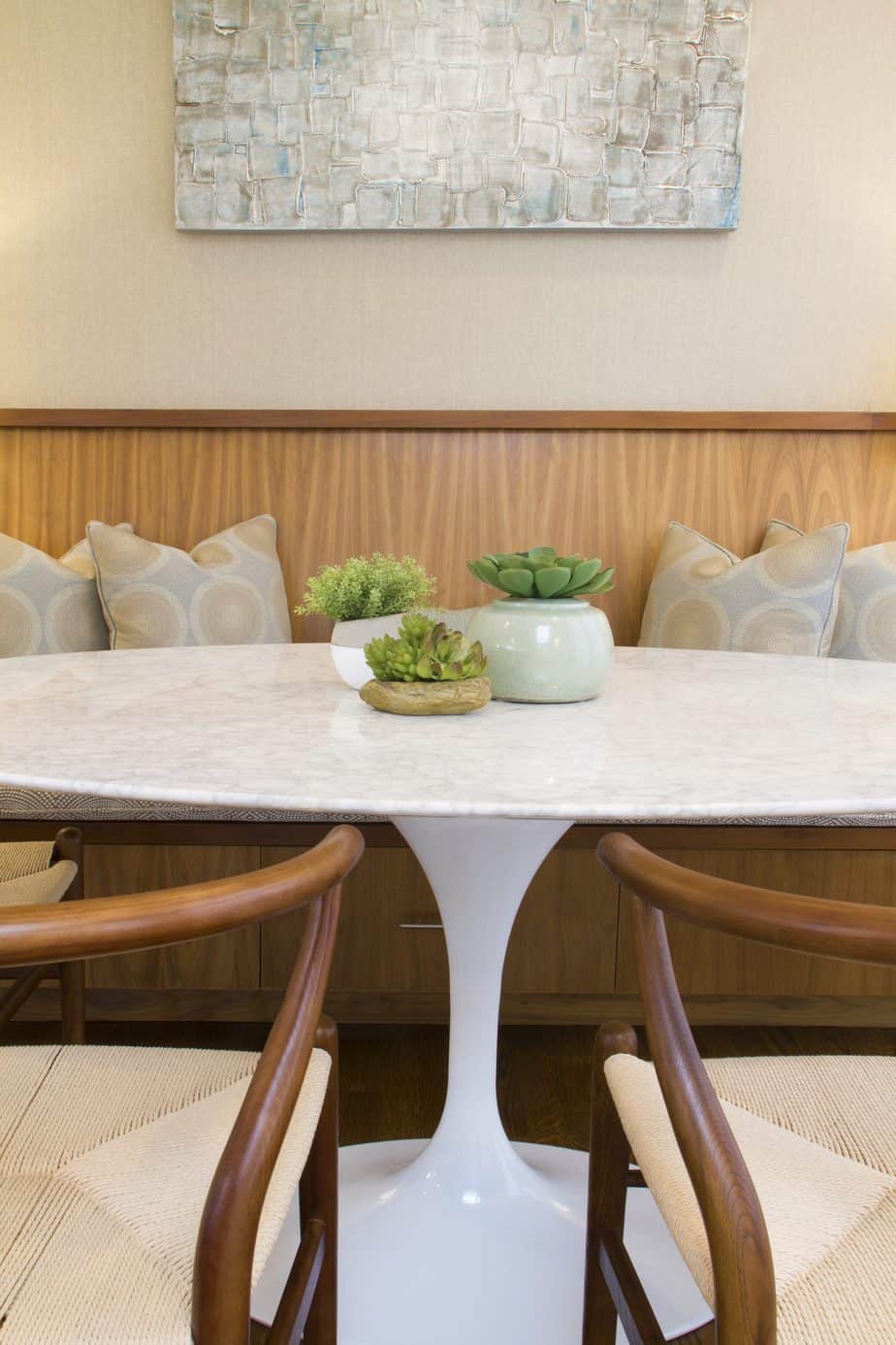 Interior Design Redondo Beach white marble tulip table dining room with wooden banquette and wishbone chairs. Manhattan Beach modern coastal home.