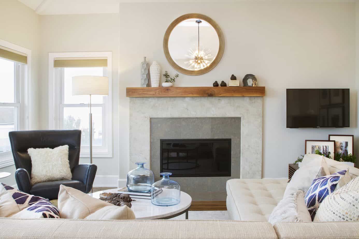 Modern Coastal Redondo Beach living room fireplace design white plaster and wooden mantle with decorative mirror above and side chair. Manhattan Beach modern coastal home